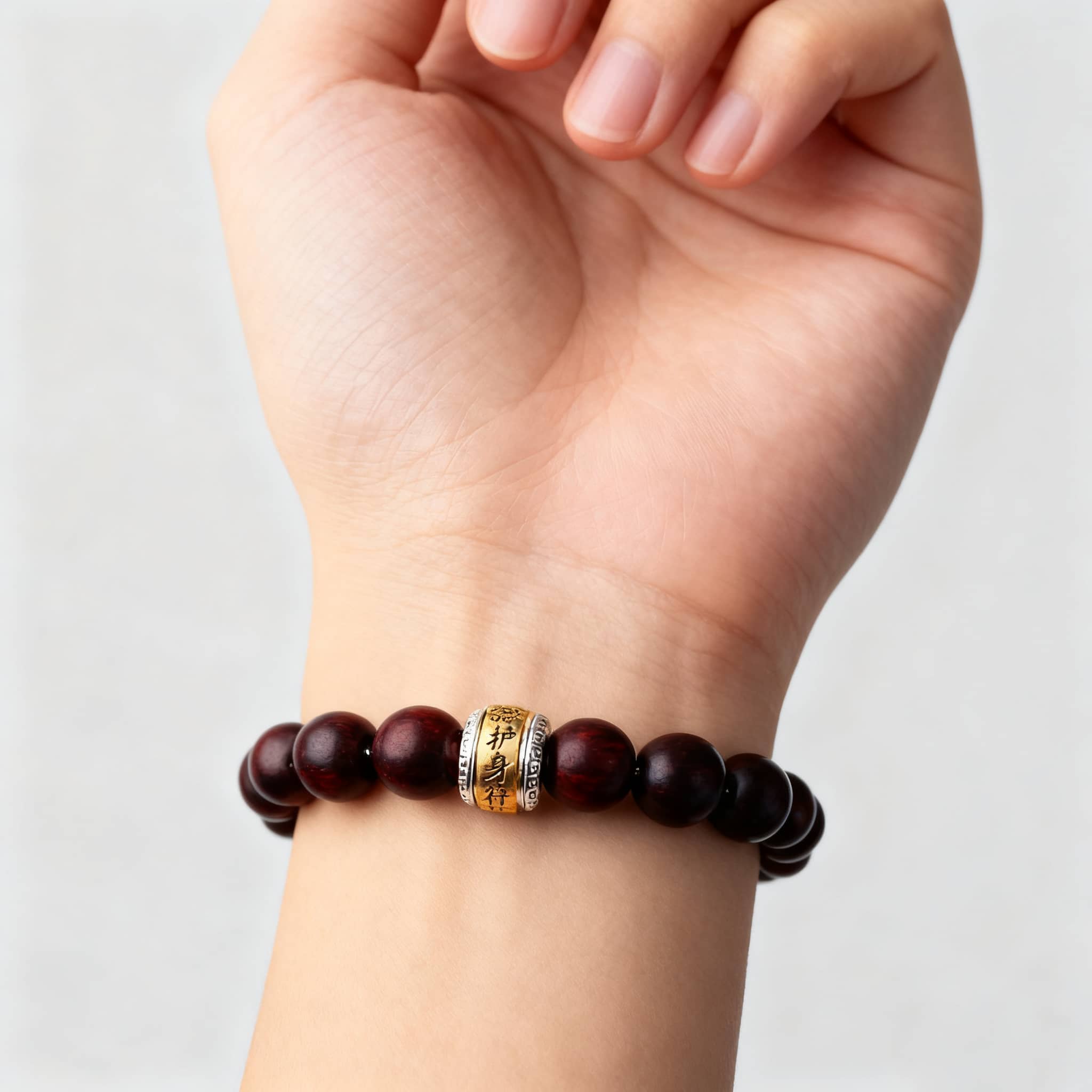 Antique rosewood mala bracelet with decorative bead on a wrist for calm and mindfulness
