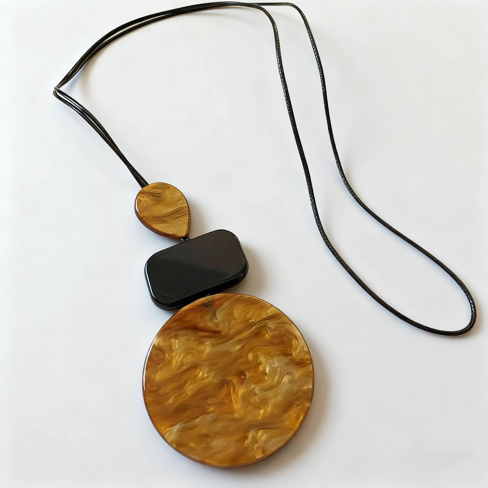Angry necklace featuring black and ochre statement jewelry with bold circular pendant design
