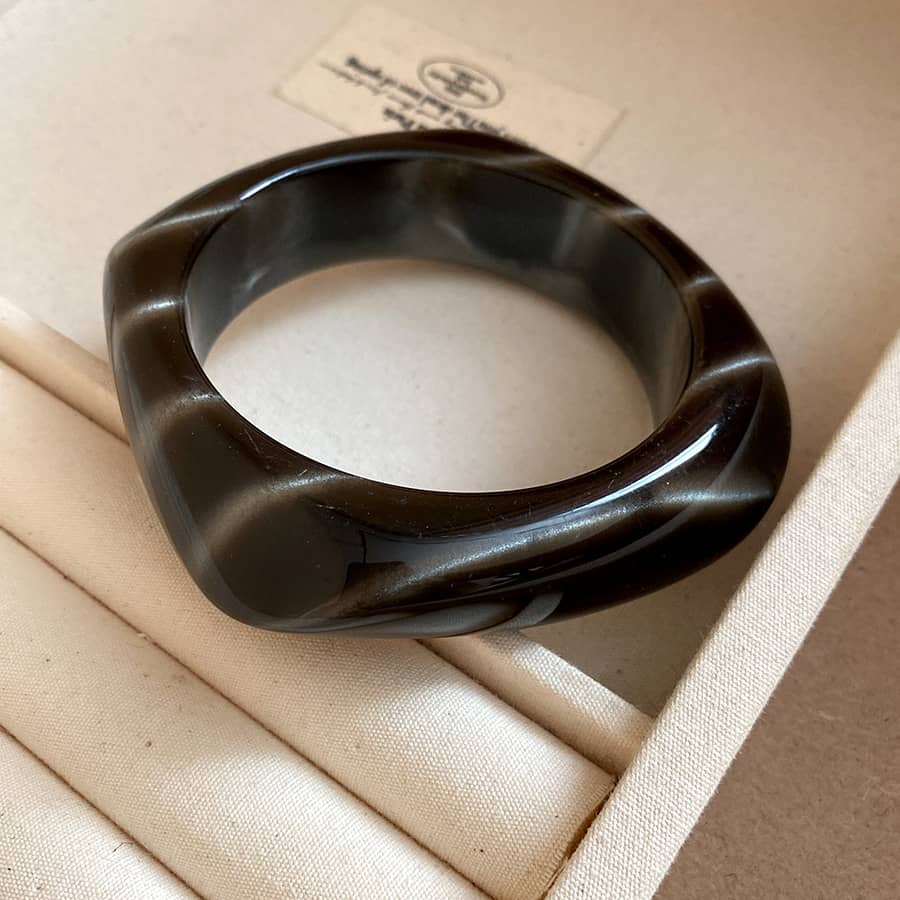 Angry black cat eye resin bracelet with a unique twisted design and glossy finish