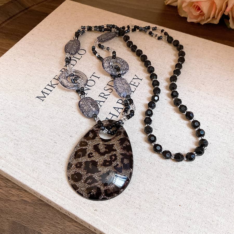 Stylish black leopard pendant necklace featuring a unique teardrop design and elegant bead details