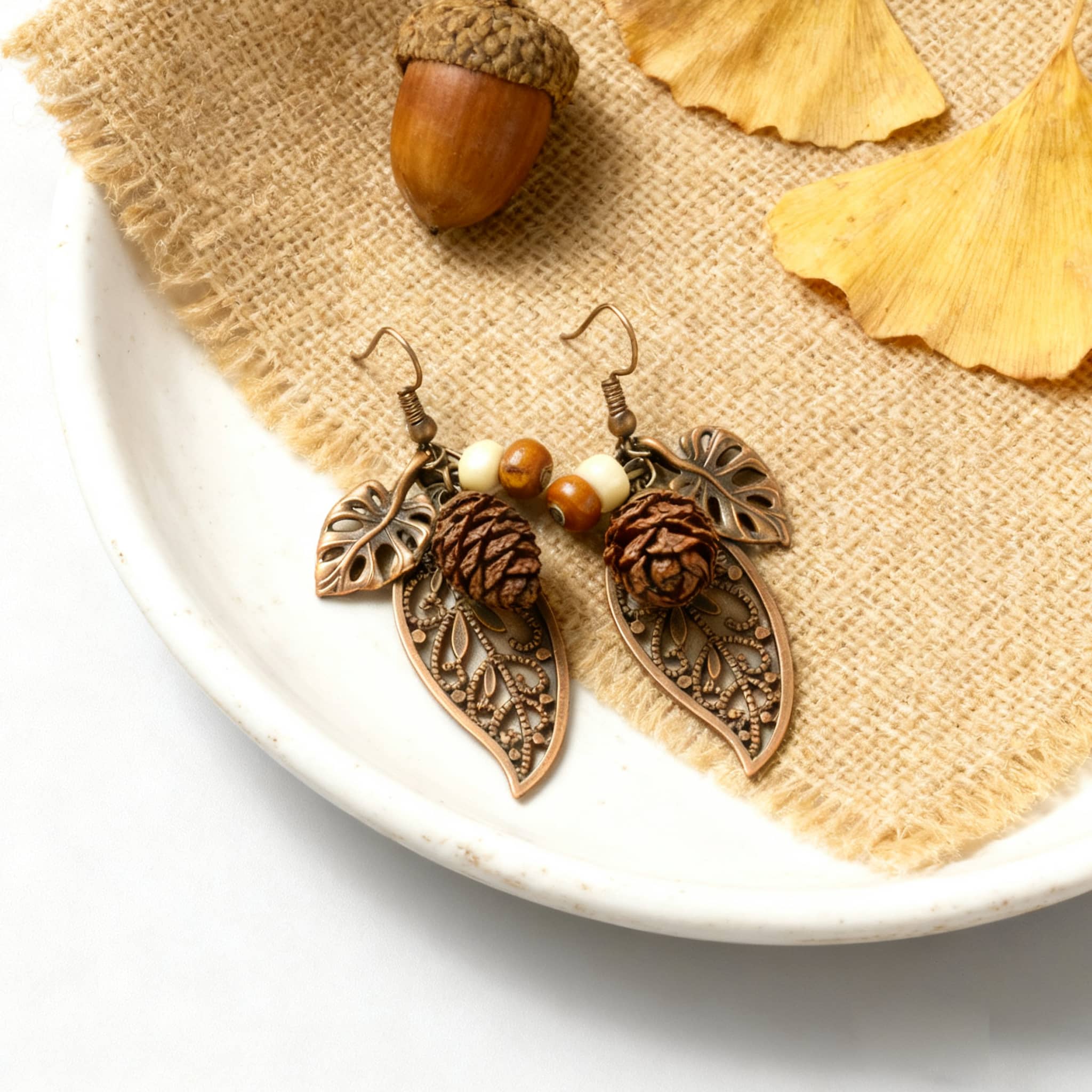 Botanical earrings with pinecone featuring delicate leaf designs and earthy tones