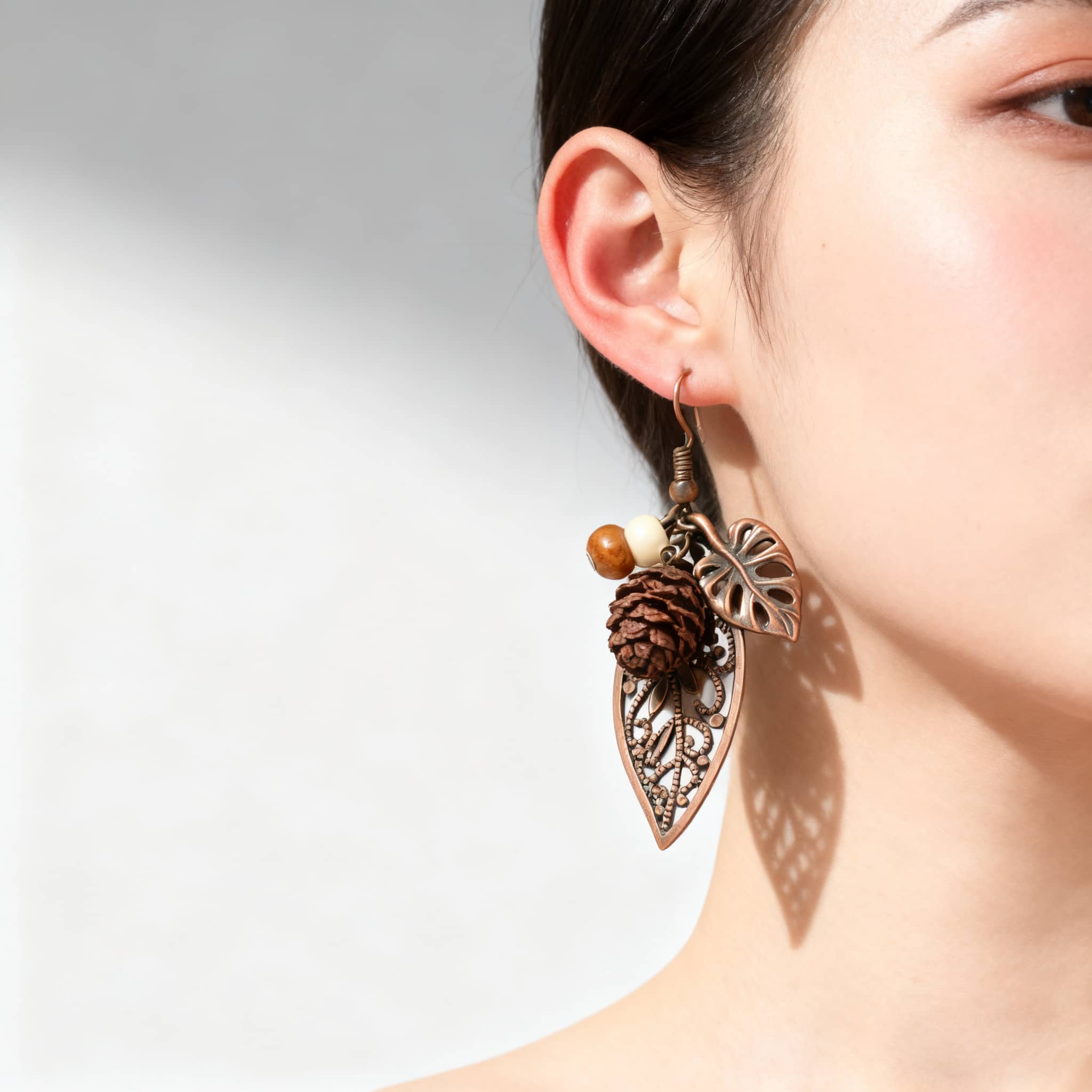 Angry botanical earrings with pinecone featuring intricate leaf designs and earthy tones