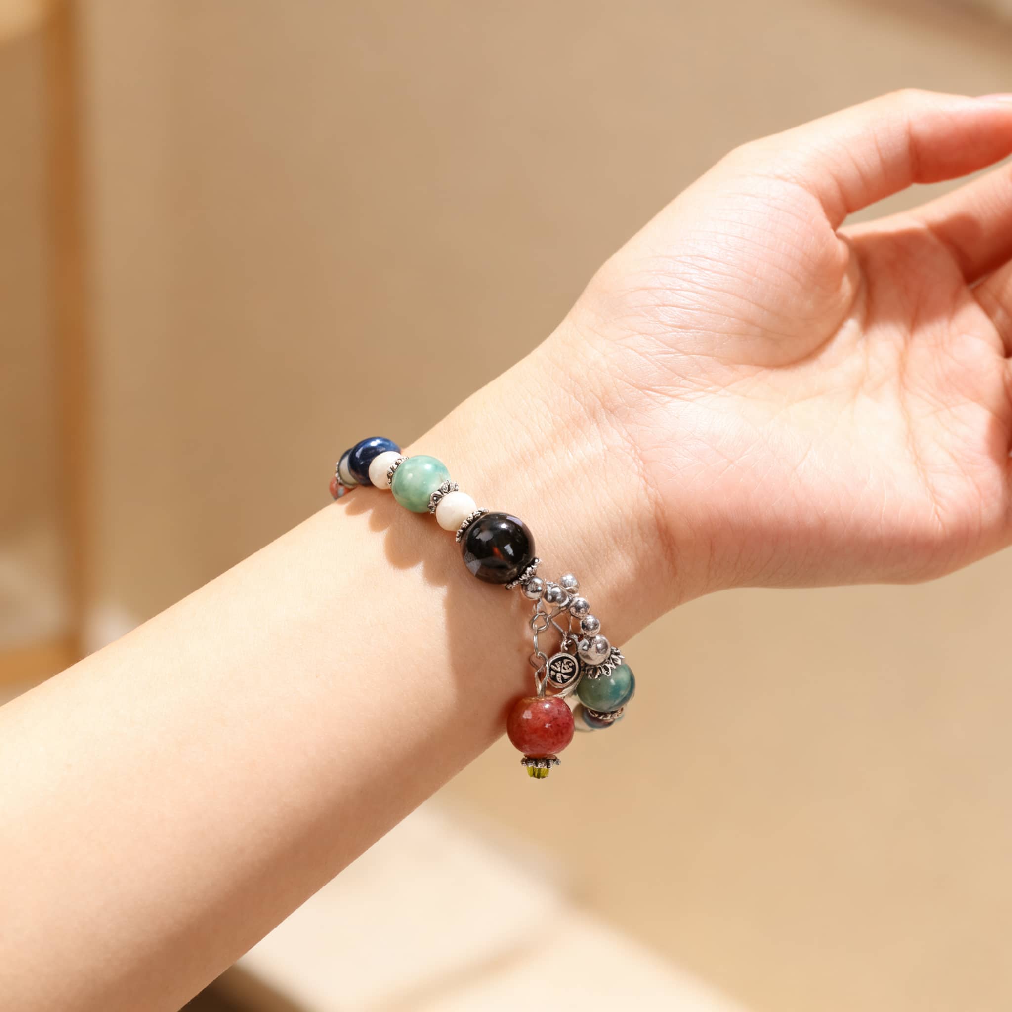 Elegant ceramic persimmon bracelet featuring colorful beads and a charming charm design