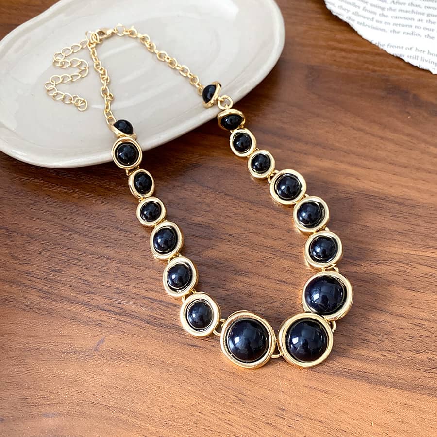Elegant geometric resin pendant necklace in gold with black stones for stylish accessorizing