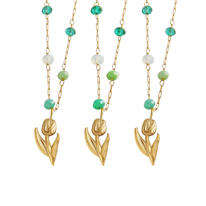 Calm necklace featuring green and clear bead jewelry with gold floral pendant on delicate chain