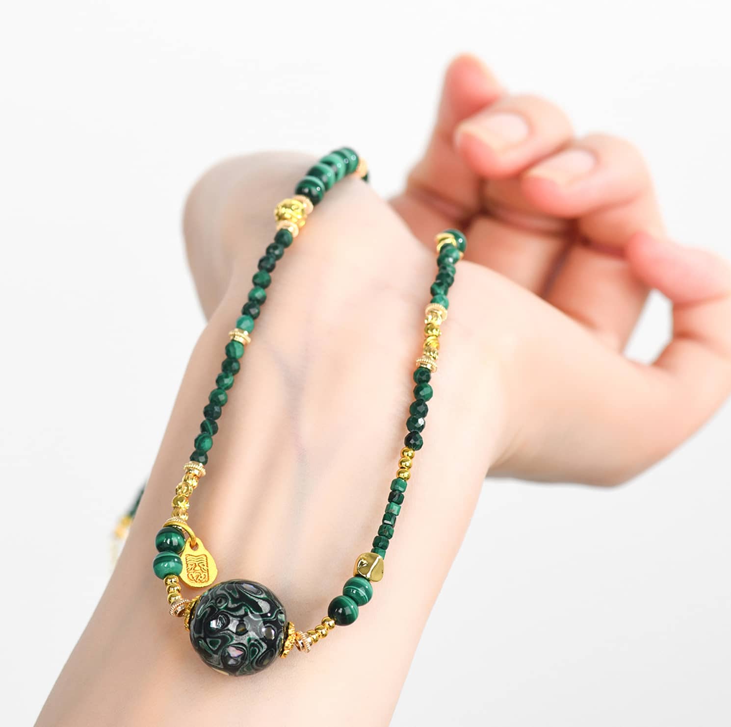 Green urushi mindfulness necklace featuring delicate gold accents and intricate beadwork