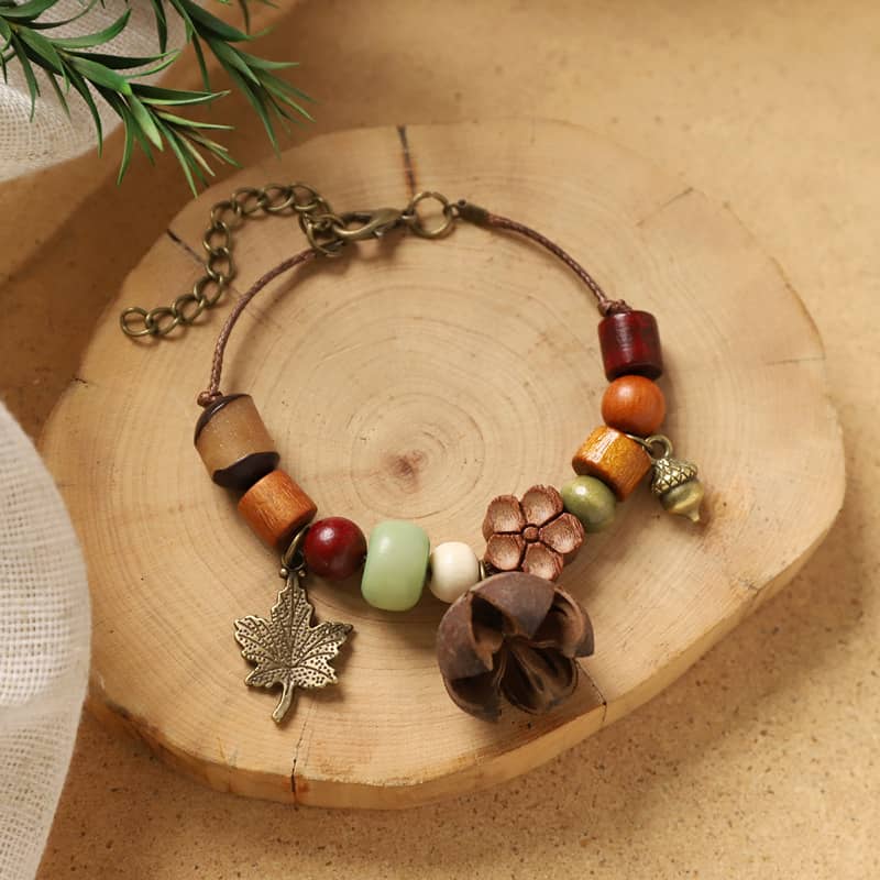 Handcrafted berry and wood bracelet with colorful beads and floral charm on a wooden background
