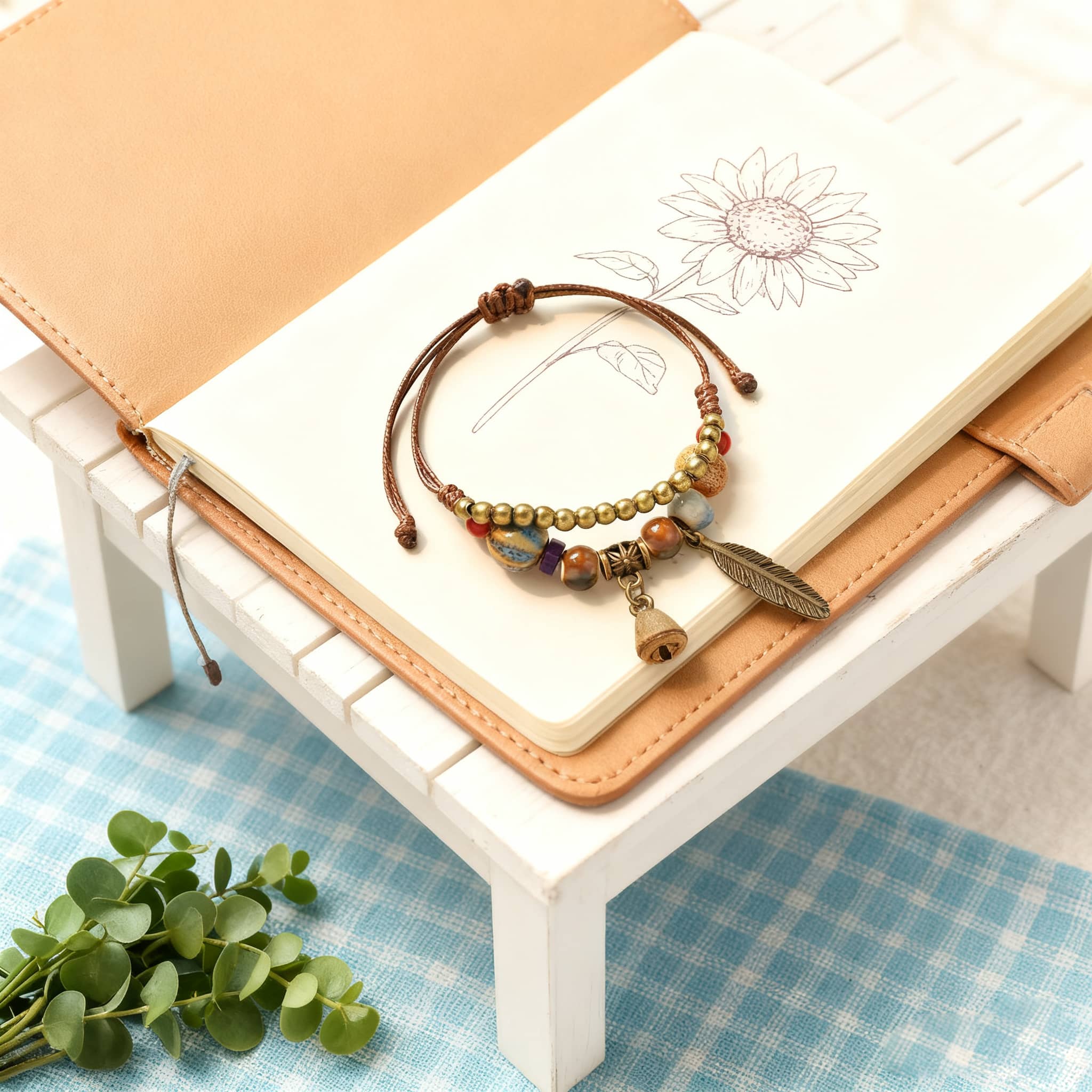 Handmade bell and bead bracelet featuring colorful beads and charms on a brown cord