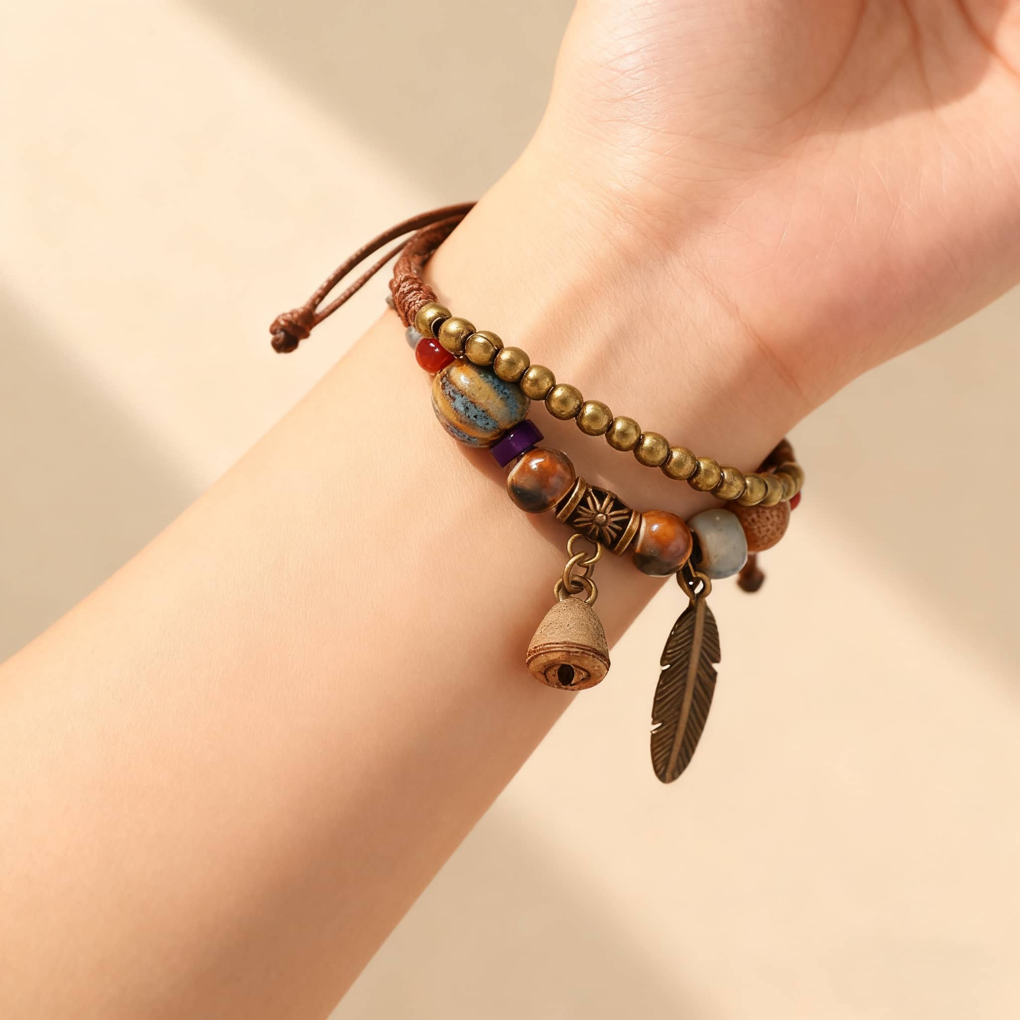 Handmade bell and bead bracelet featuring colorful beads and charm details on a wrist