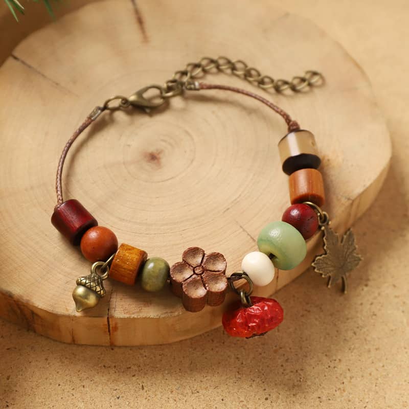 Red berry wood bead bracelet featuring assorted wooden beads and a charm for a unique accessory