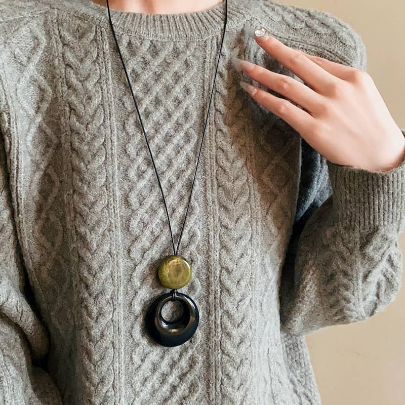 Angry resin pendant necklace for mindfulness displayed elegantly on a model in a cozy sweater
