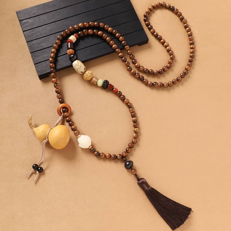 Calm Necklace with sandalwood bead cross-body chain and decorative tassel accents