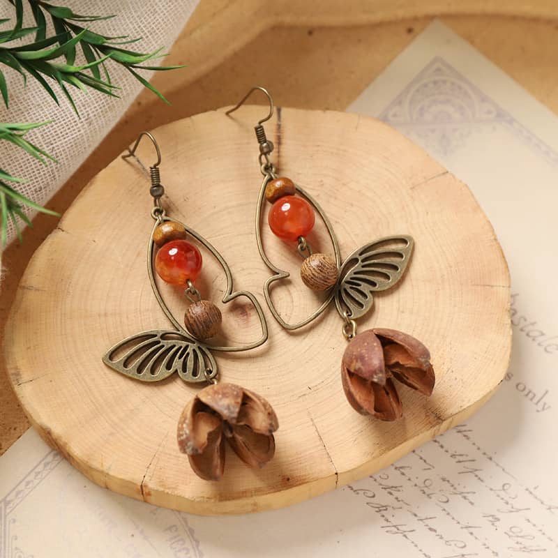 Vintage butterfly earrings in bronze with red beads and floral accents, perfect for a unique look