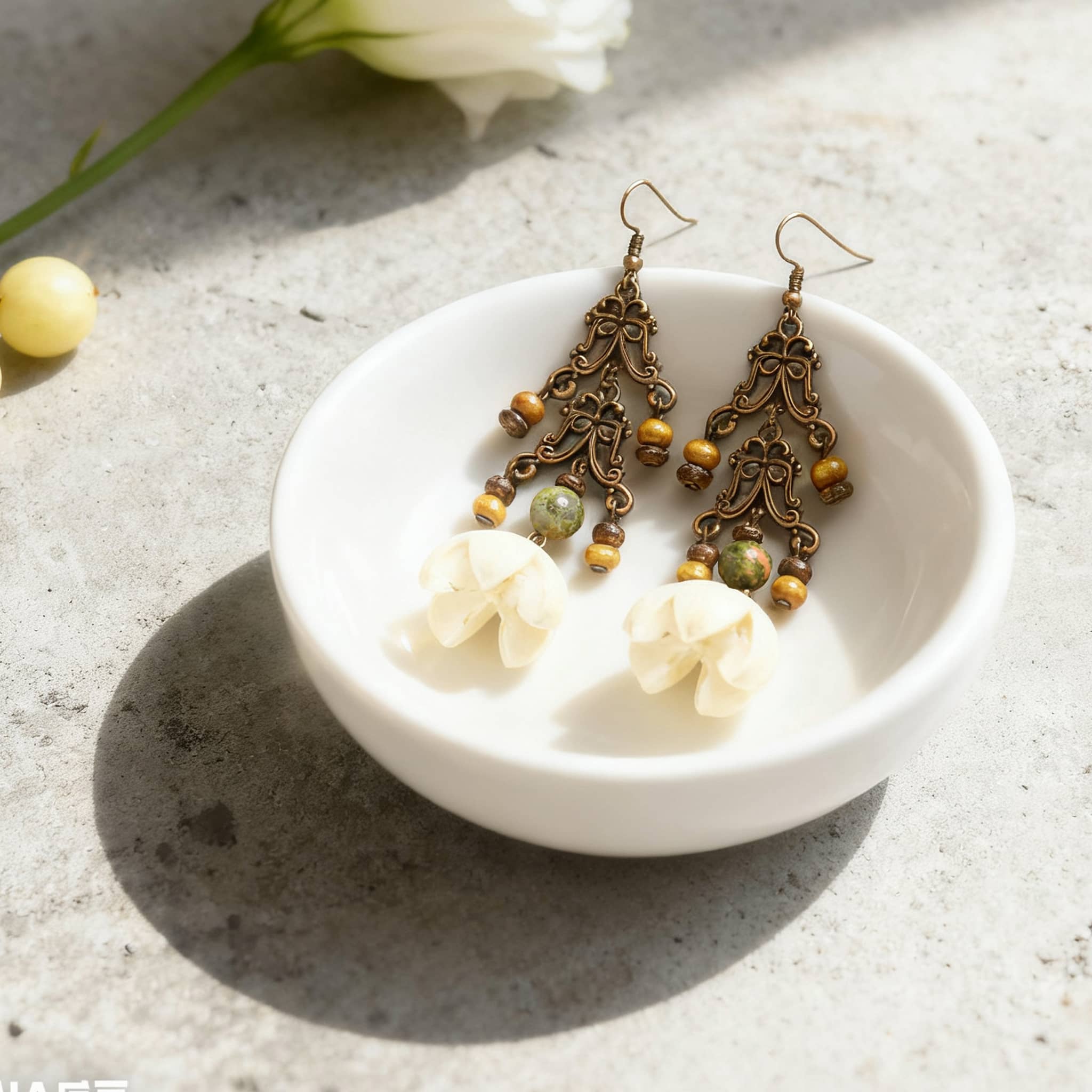 Vintage cut-out metal earrings featuring floral design and colorful beads in a stylish bowl