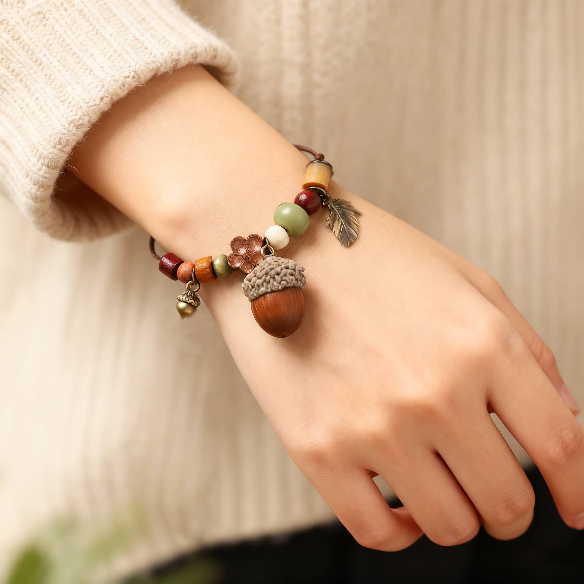 Hand wearing a wood bead acorn bracelet featuring colorful beads and charm details