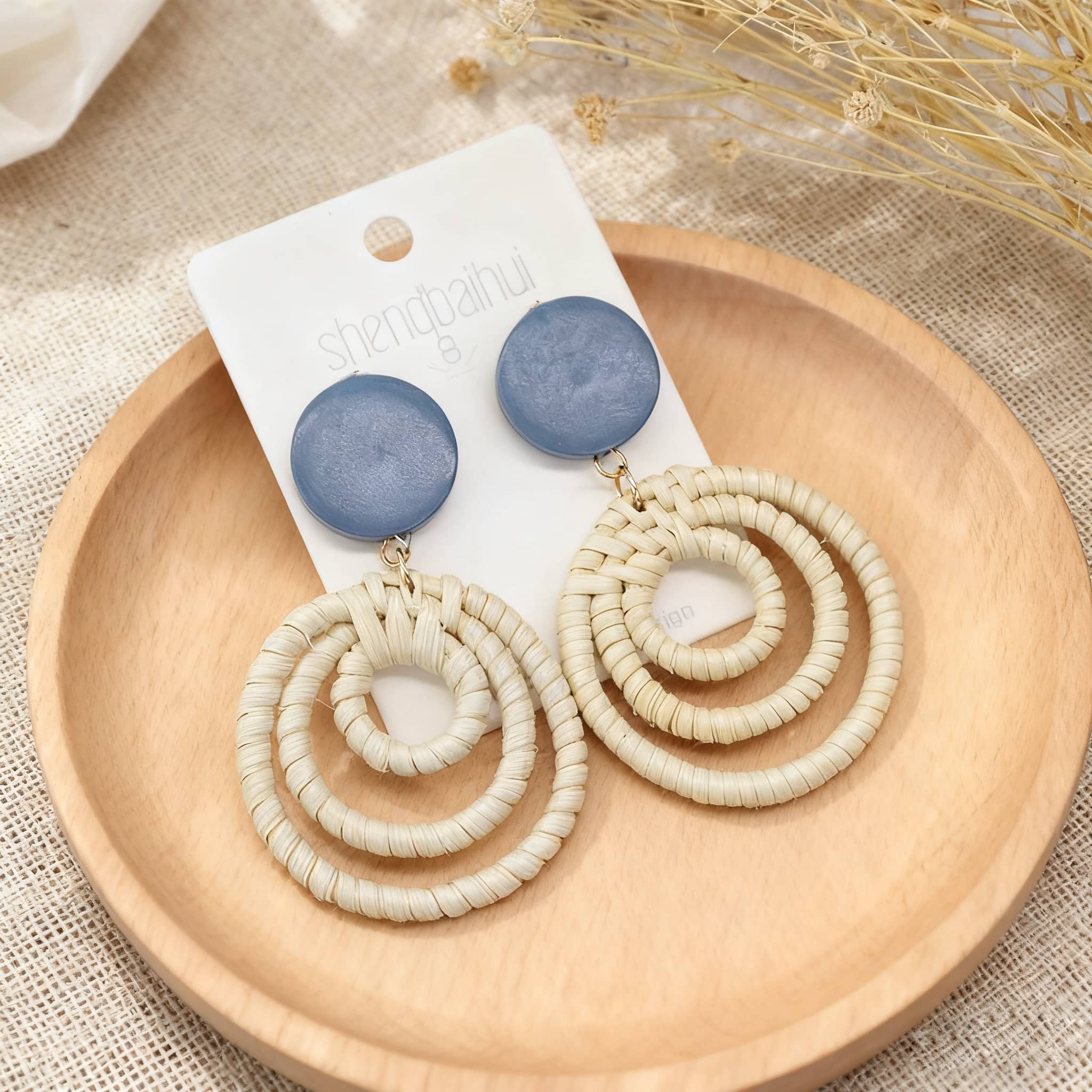 Woven bamboo statement earrings featuring circular designs and blue accents for a stylish look