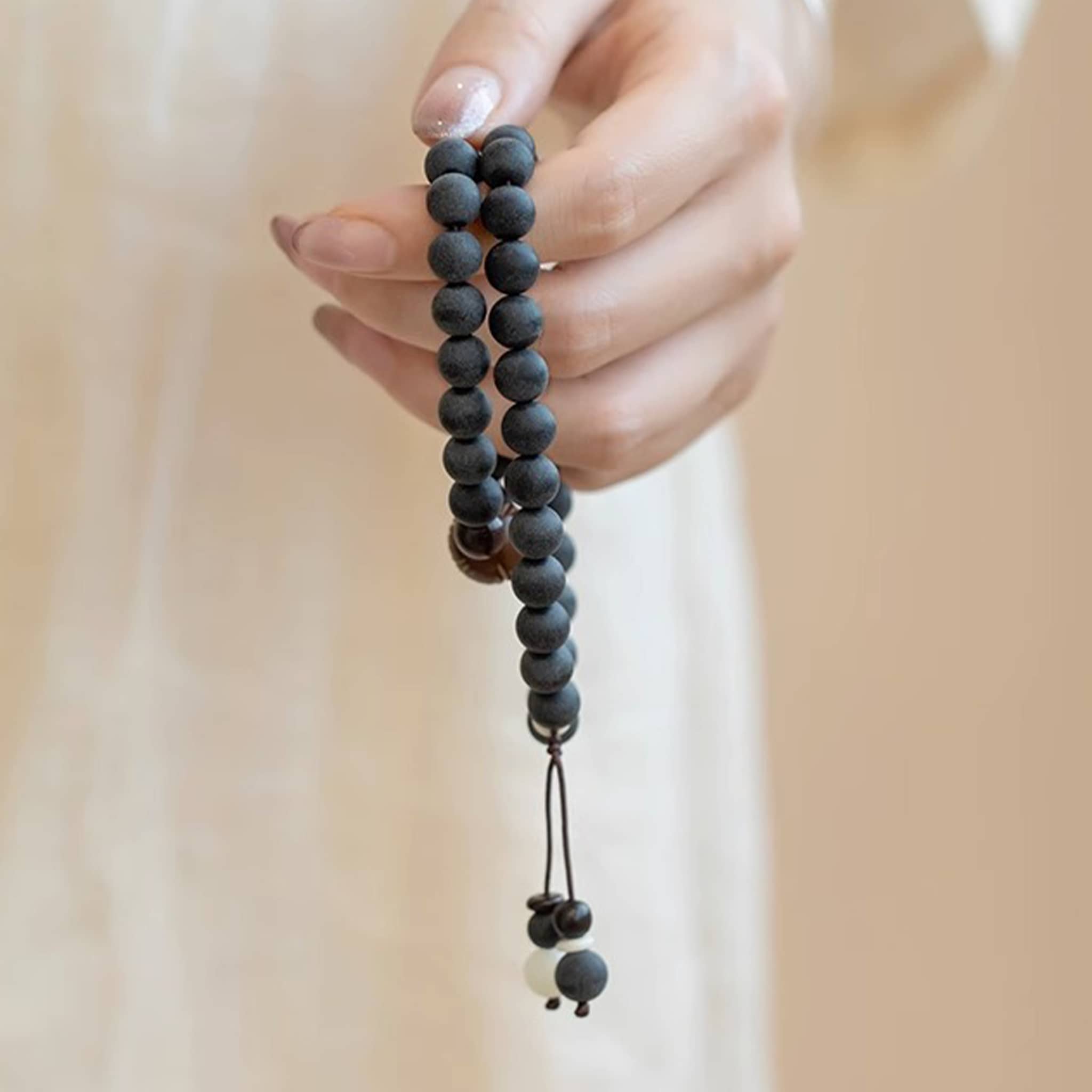 Hand holding a calming mala bracelet, perfect for how to find stillness in a busy day