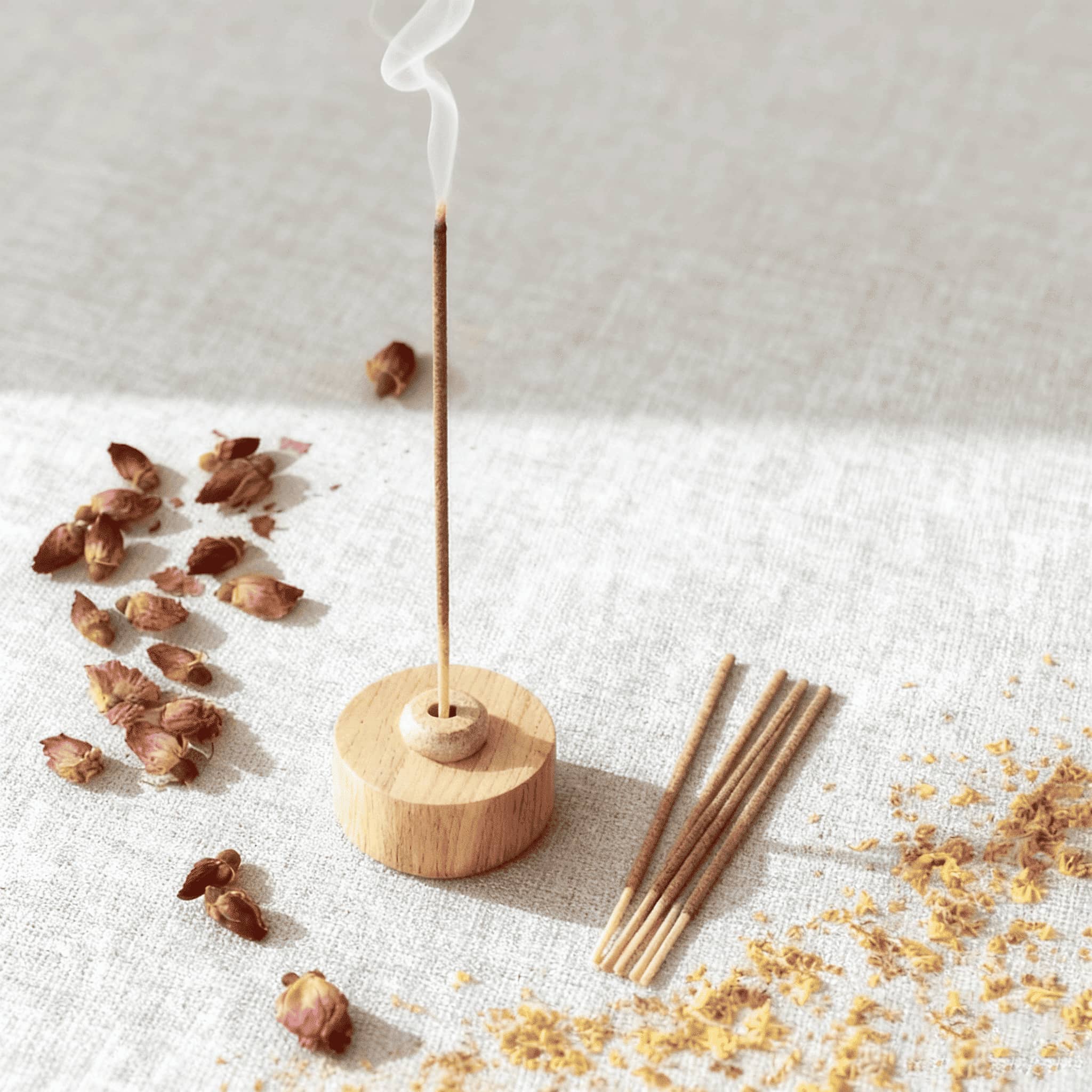 Morning ritual ideas for women featuring incense with smoke and natural elements on a soft surface