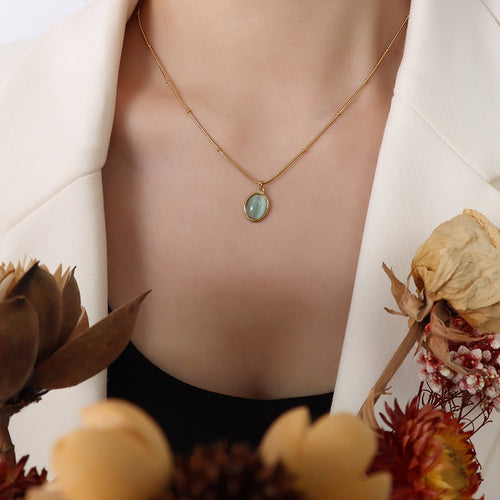 18K gold green cat's eye necklace worn around the neck with a pendant on a gold chain