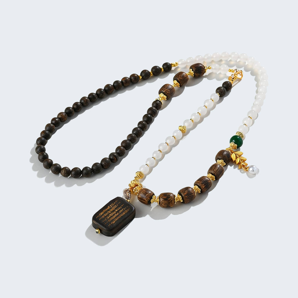 Anxious Necklace featuring agarwood and white onyx jewelry with decorative gold accents
