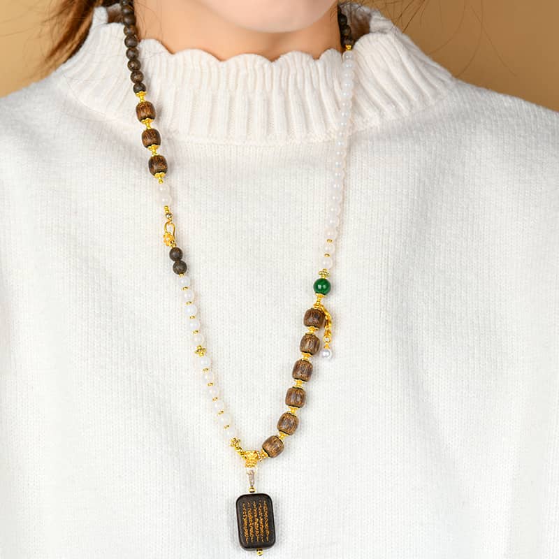 Anxious necklace featuring agarwood and white onyx jewelry with gold accents