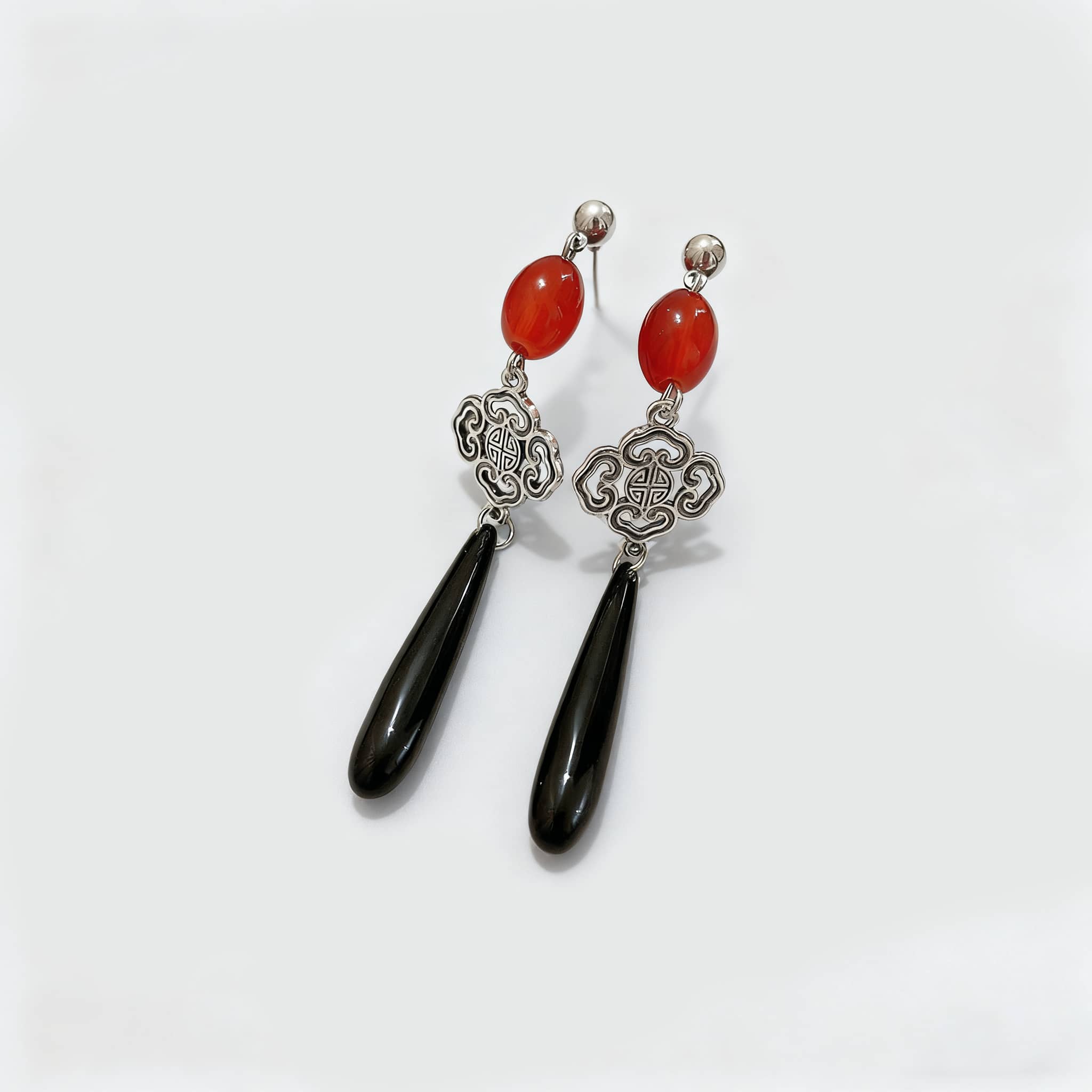 Stylish anger teardrop earrings featuring red stones and elegant silver designs