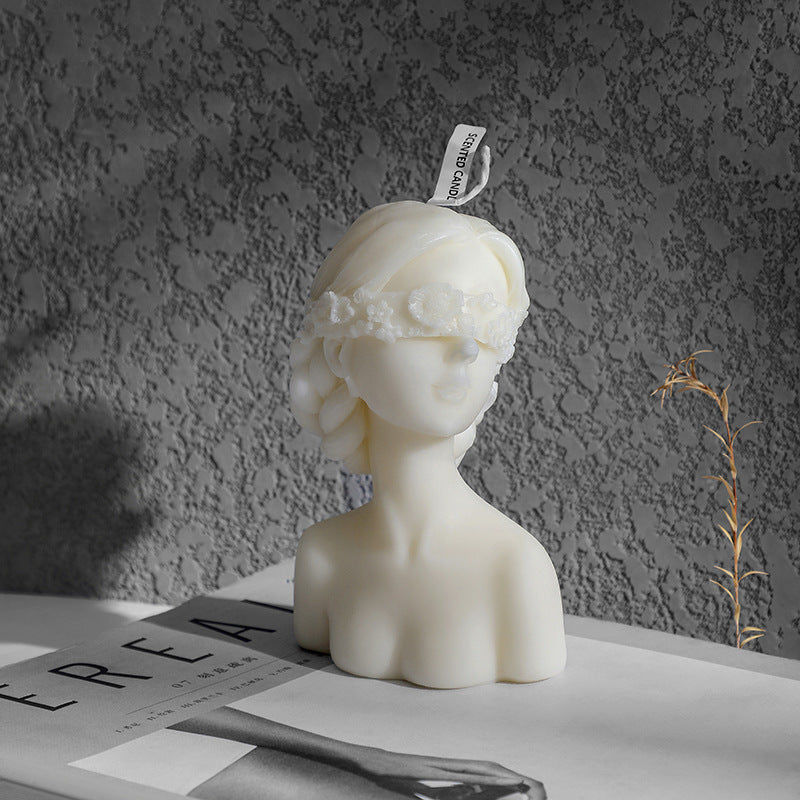 White bust sculpture aromatherapy art candle gift with floral blindfold on textured background