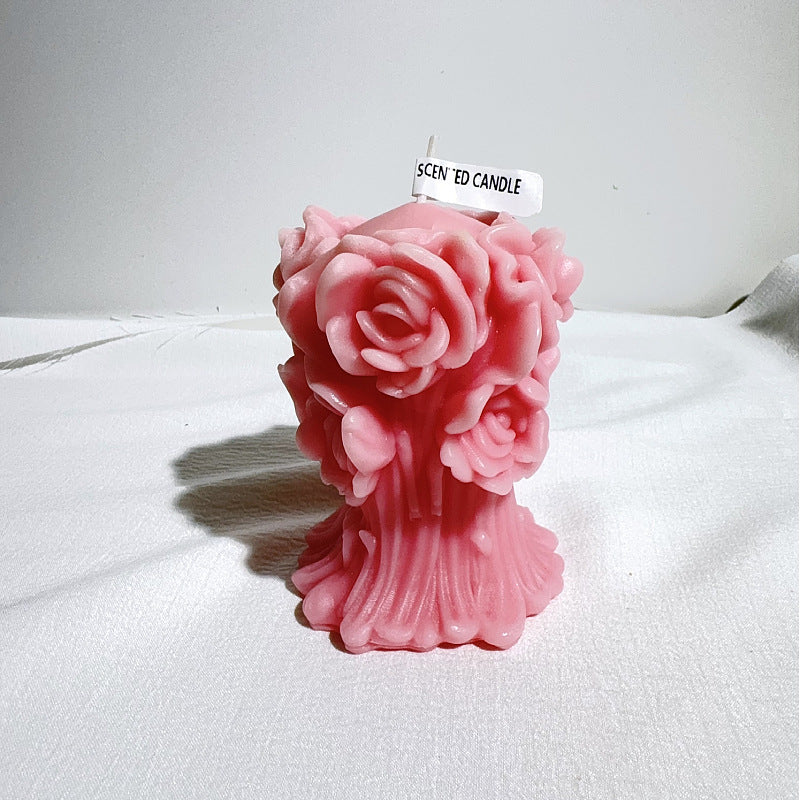 Pink aromatherapy rose candle shaped like blooming roses with detailed petals on white background