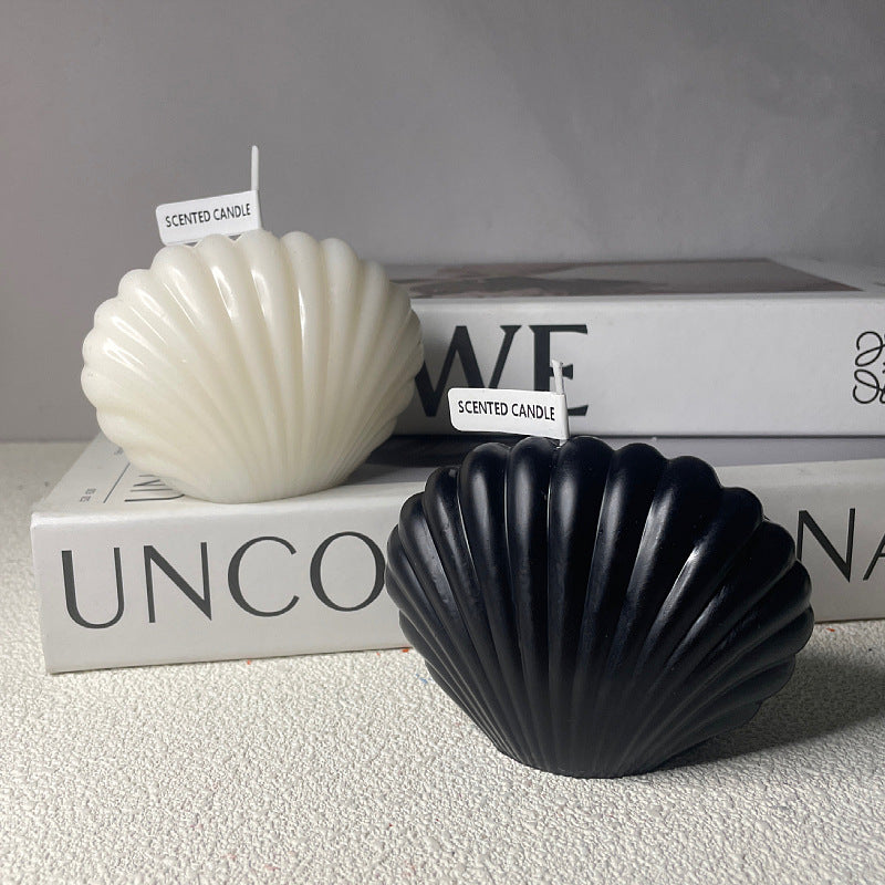Black and white aromatherapy shell candle shaped like seashells placed on stacked books