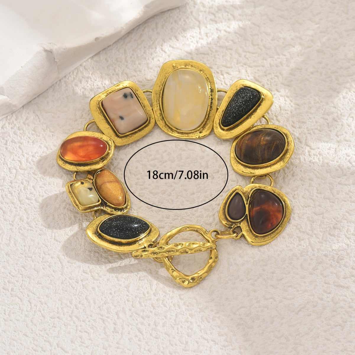Gold tone multicolor gemstone bracelet with varied oval and teardrop stones and 18 cm length