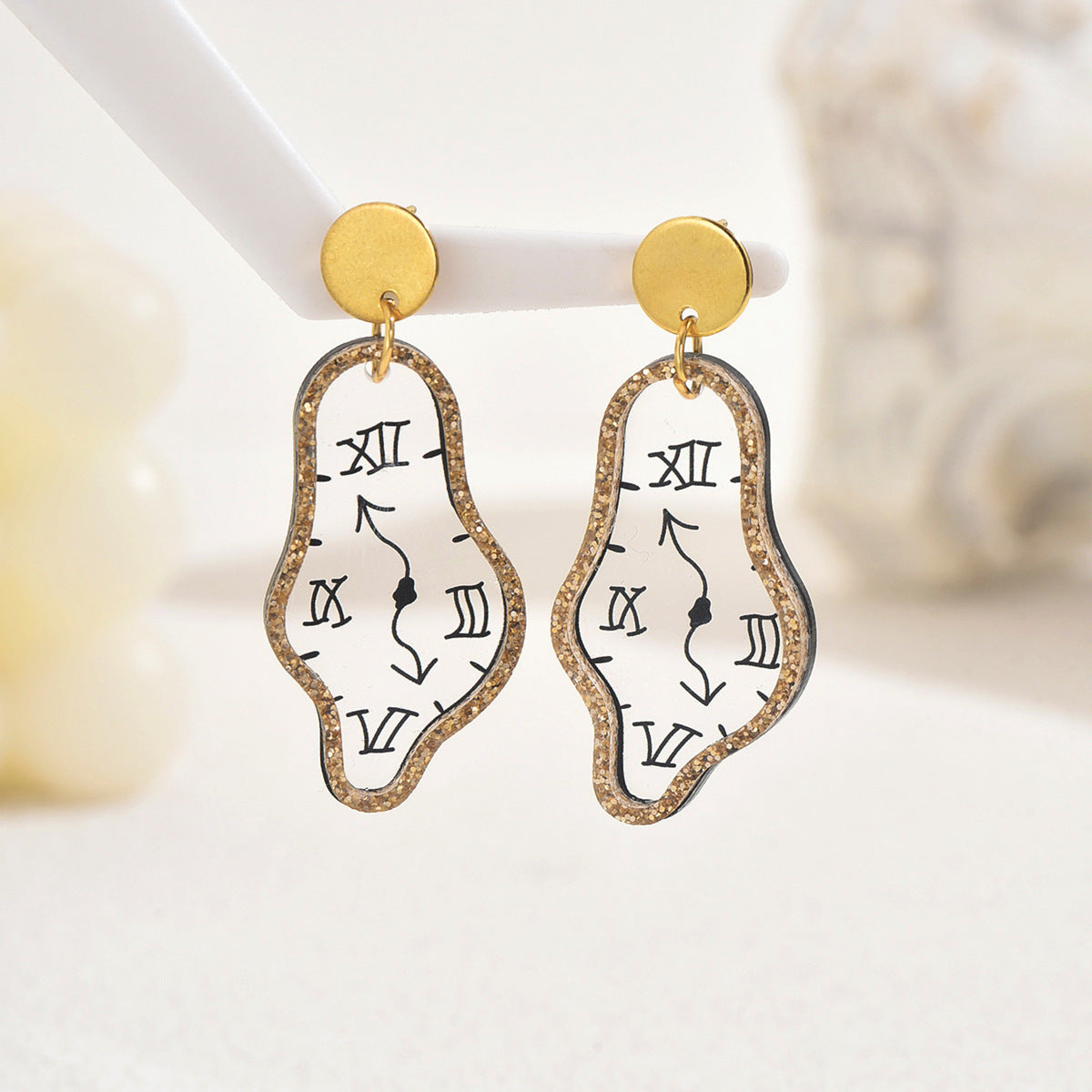 Gold stud dangle earrings with melted clock motif face black Roman numerals glitter border irregular design statement earrings