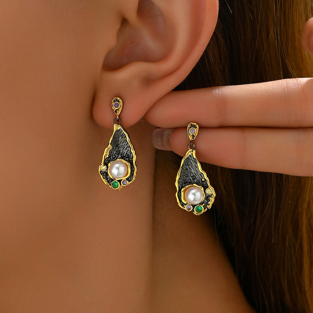 Gold teardrop zircon statement earrings with black textured interior and central pearl with green and purple accents
