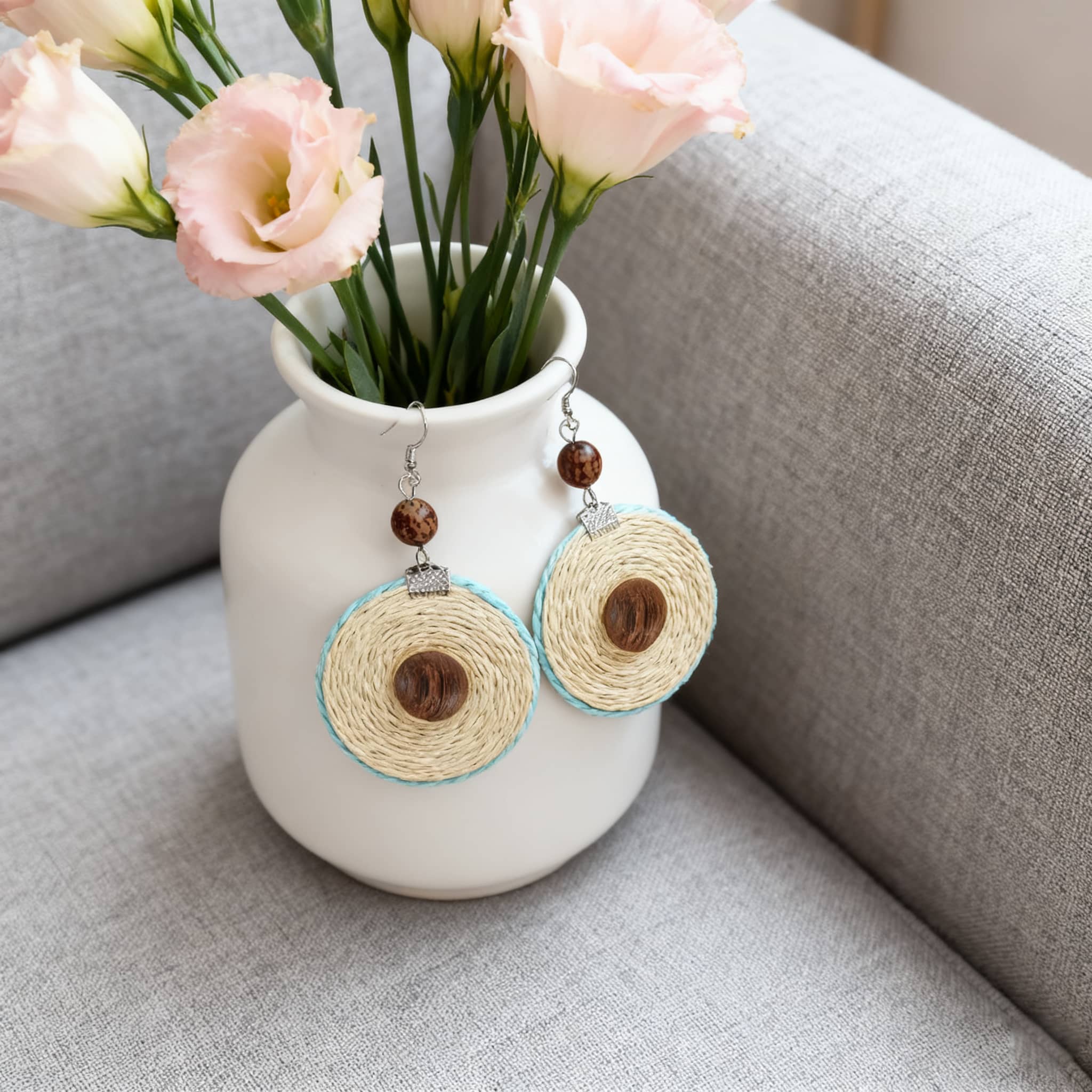 Stylish bamboo mandala earrings with wooden accents displayed beside a flower vase