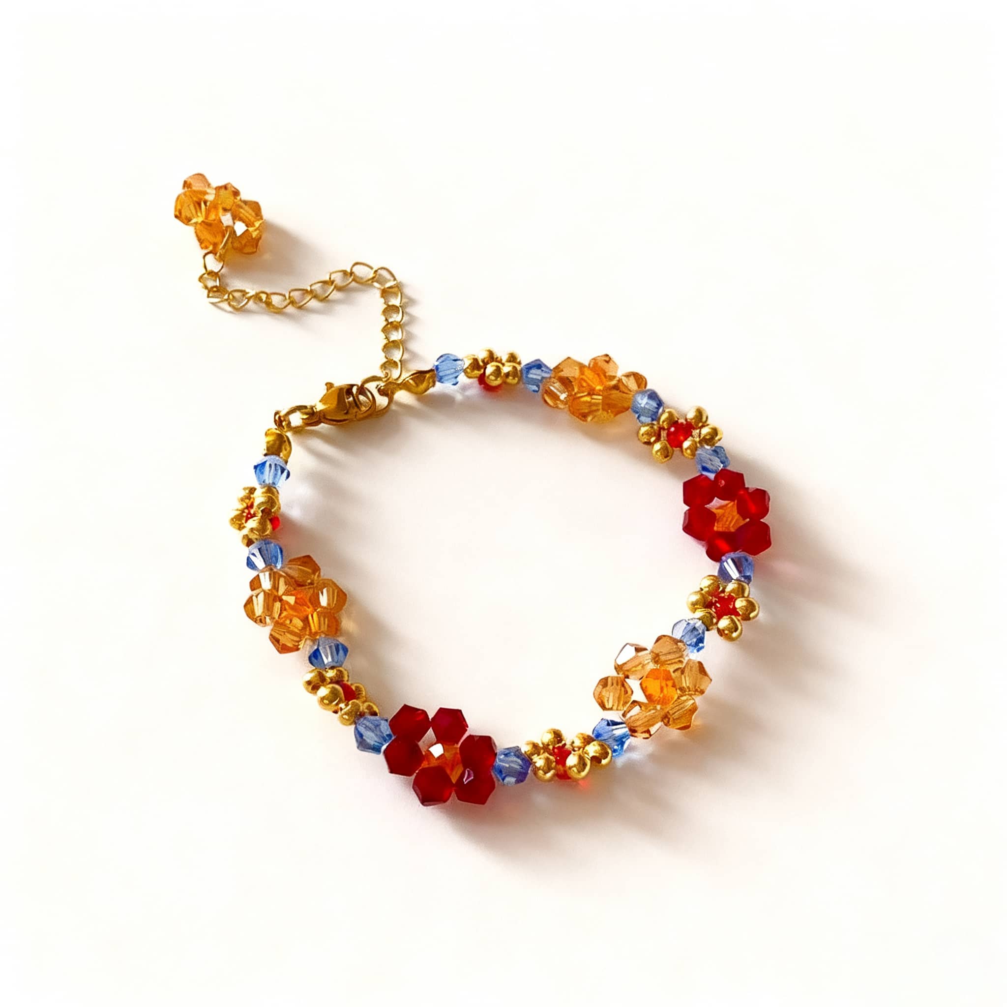 Colorful beaded flower bracelet with red and orange flowers and golden accents