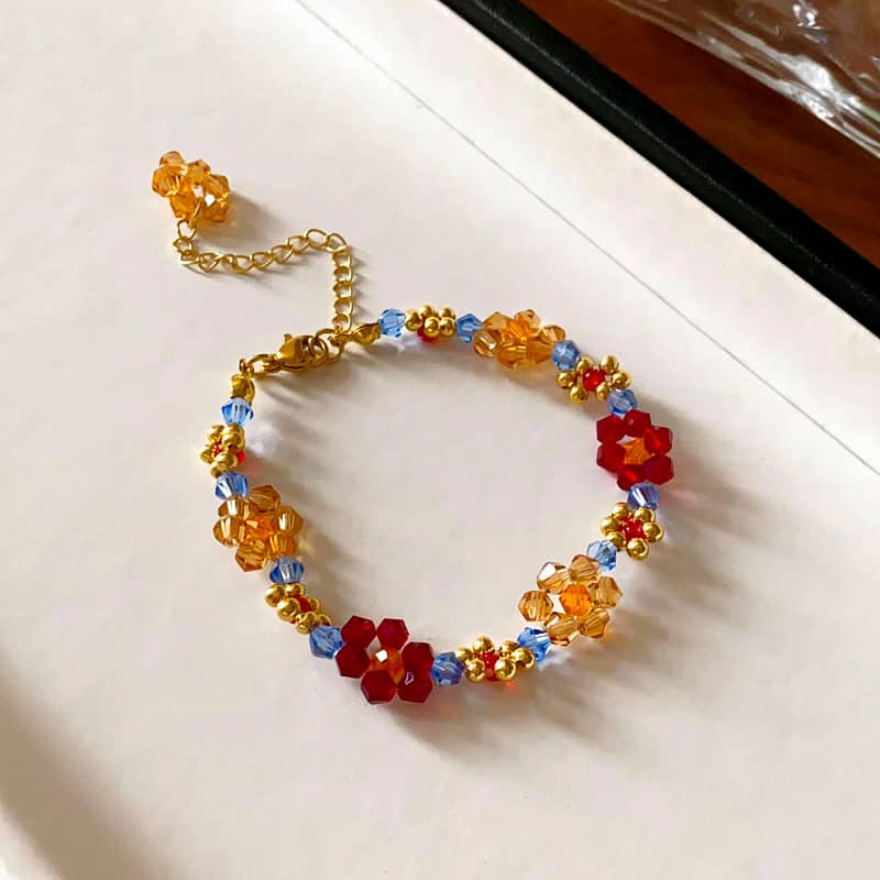 Colorful beaded flower bracelet featuring red and orange beads for joyful style