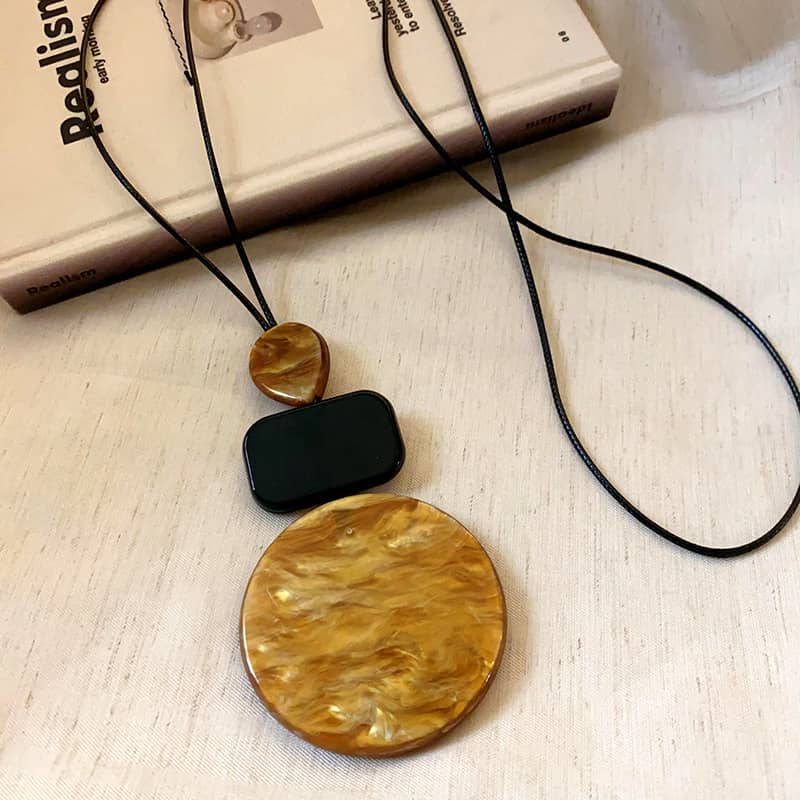 Angry necklace featuring black and ochre statement jewelry with a unique circular pendant
