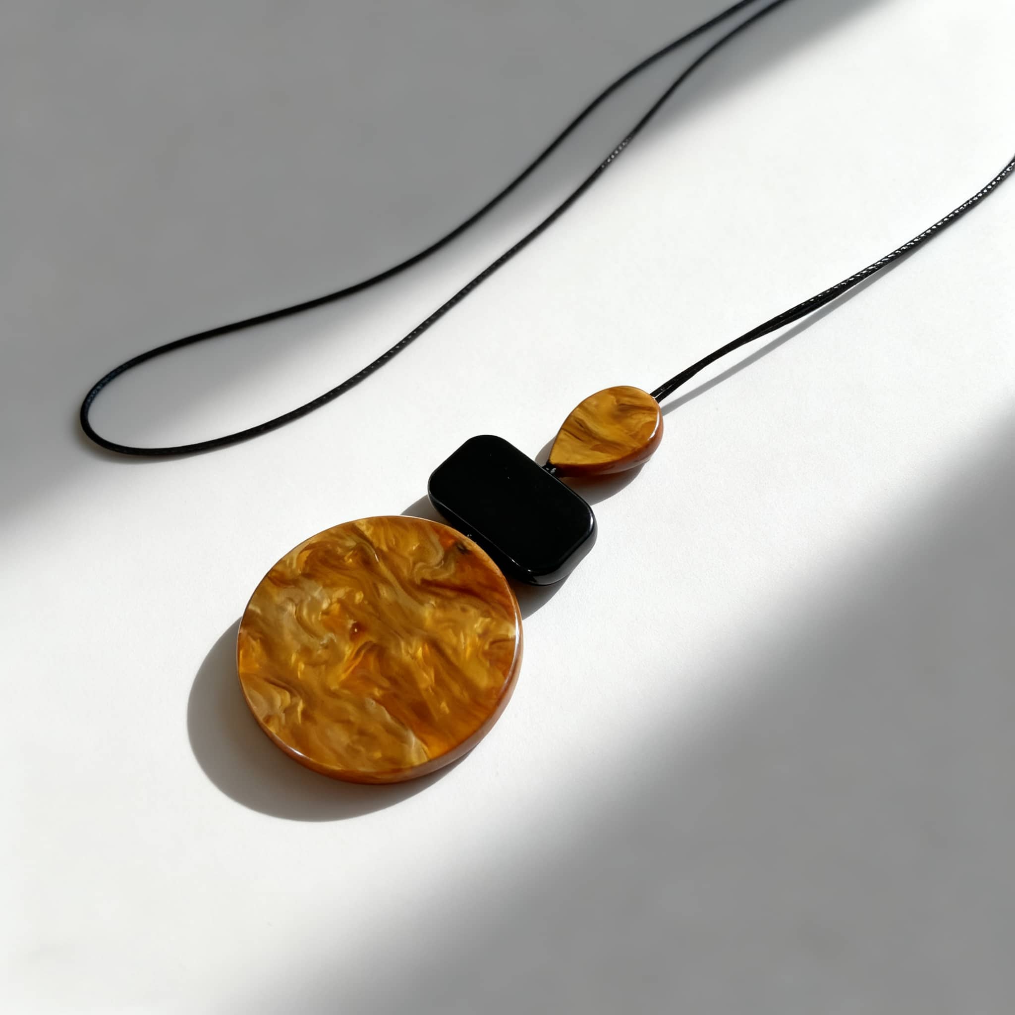 Unique black and ochre statement jewelry necklace with bold circular and rectangular pendants