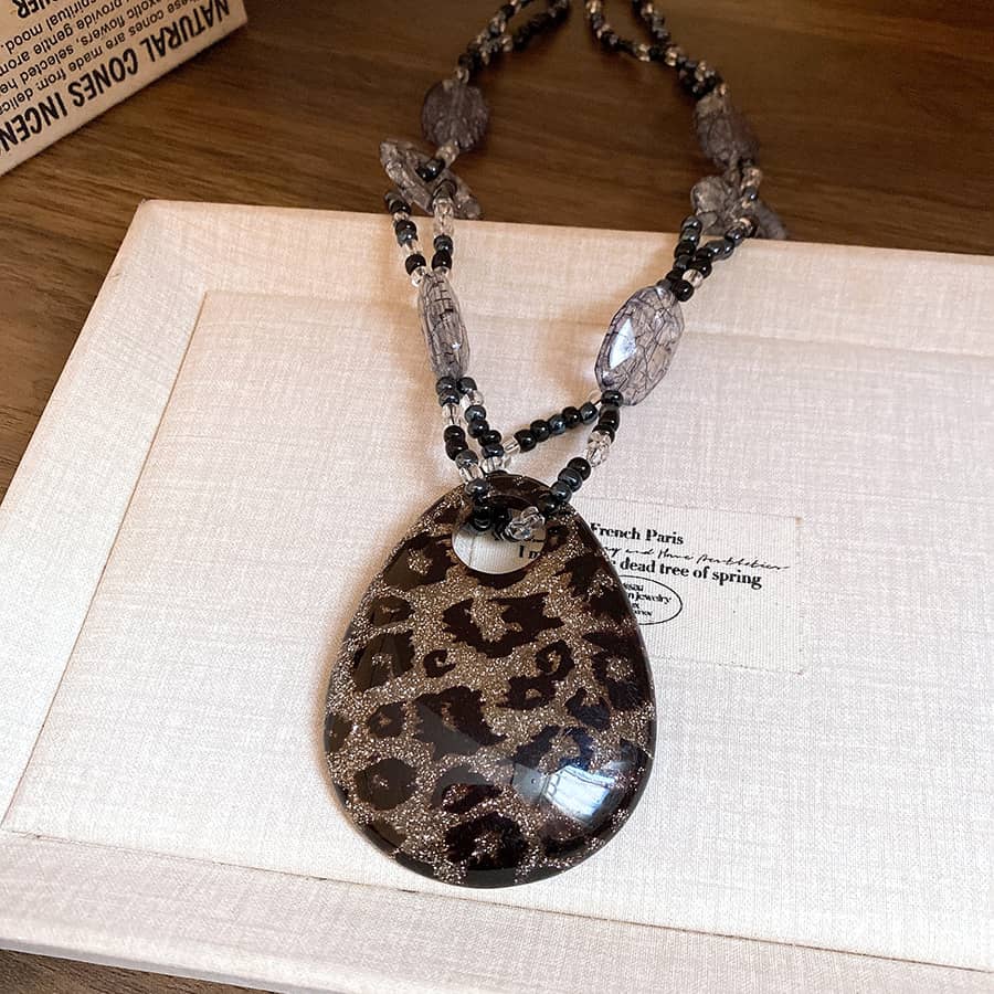 Black leopard pendant necklace featuring a stylish leopard print and elegant beaded chain