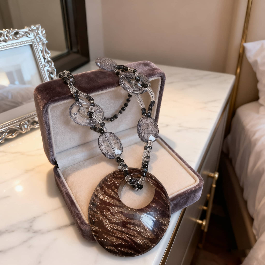 Elegant black leopard pendant necklace displayed in a jewelry box with clear beads