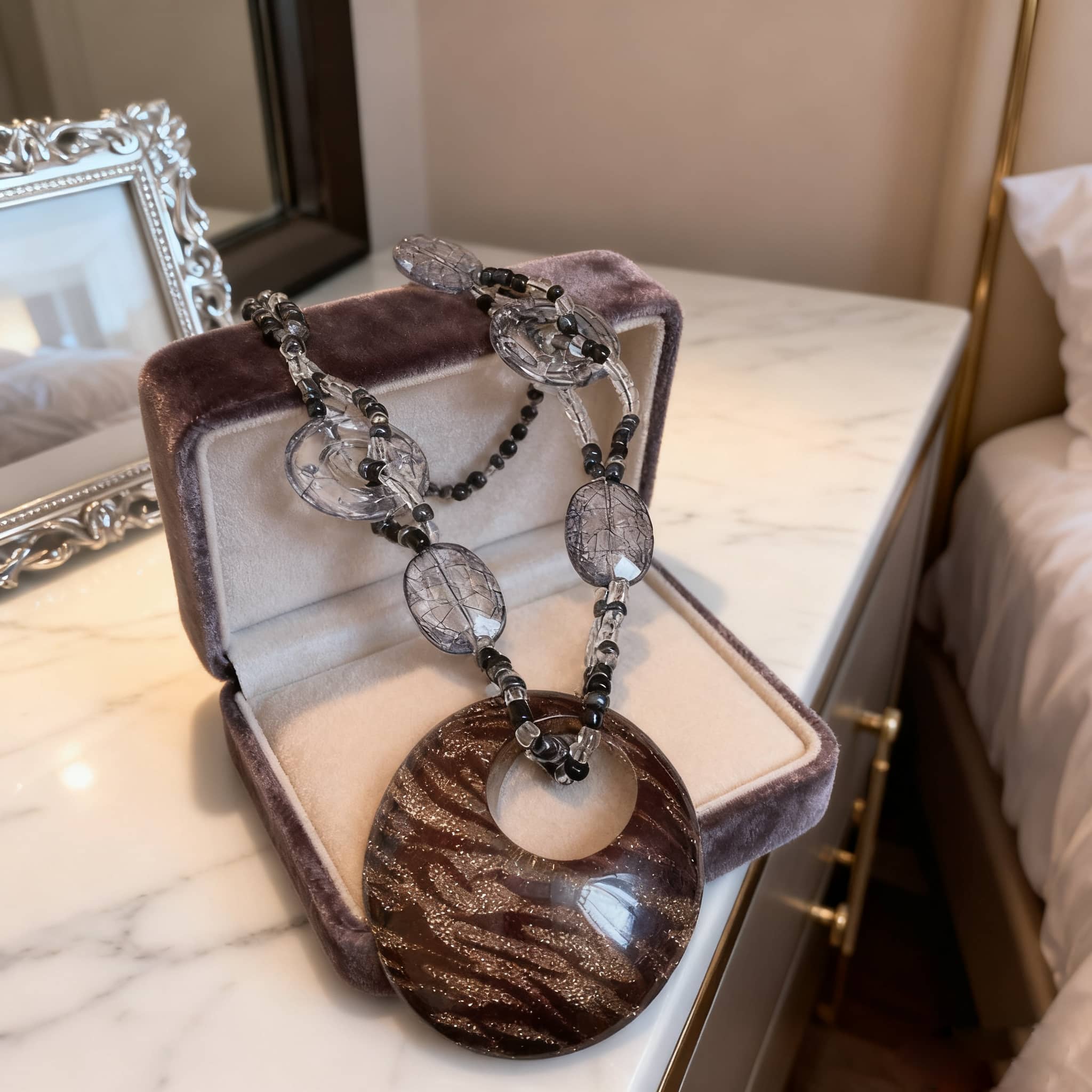 Elegant black leopard pendant necklace displayed in a jewelry box with clear beads