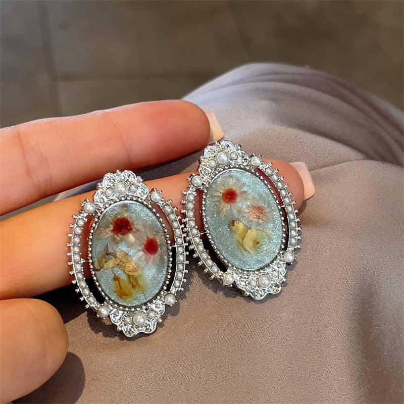 Elegant blue amber earrings for women with intricate designs and pearl accents