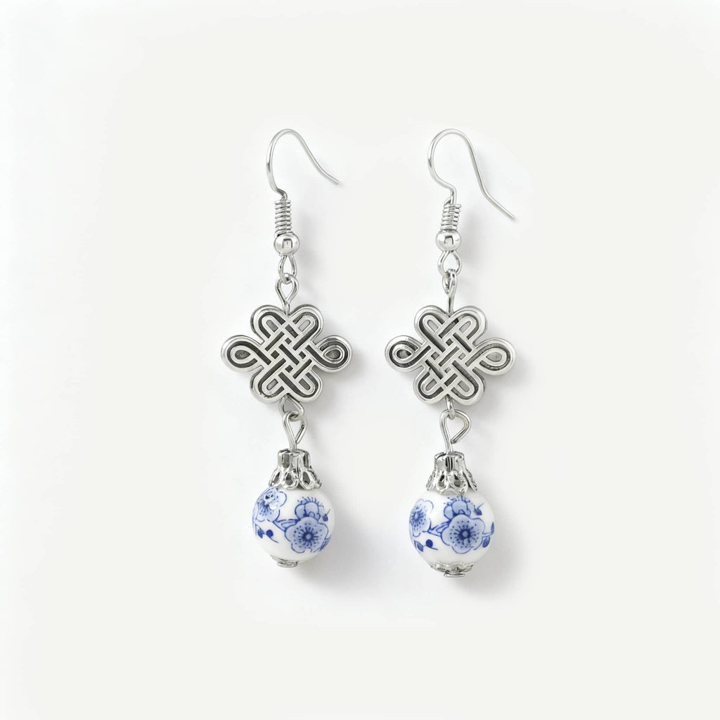 Elegant blue and white ceramic knot earrings featuring silver accents and a unique design