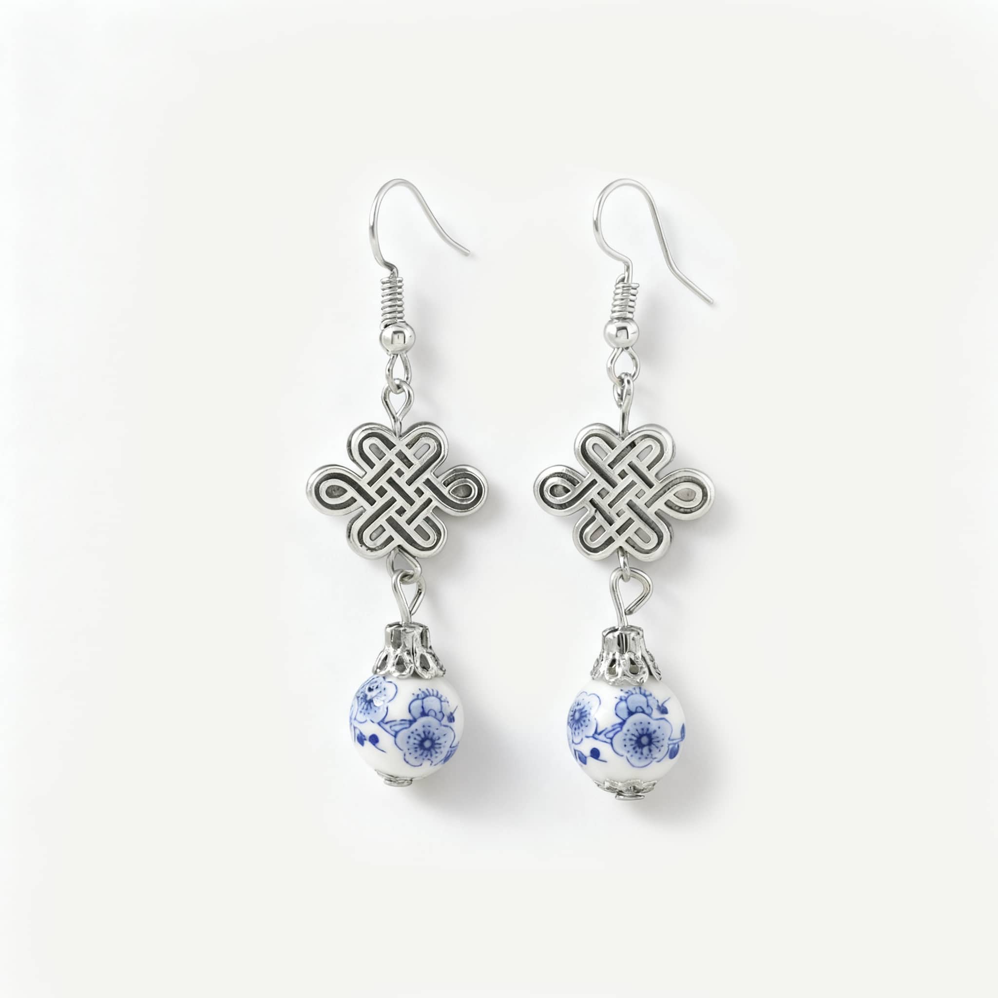 Elegant blue and white ceramic knot earrings featuring silver accents and a unique design