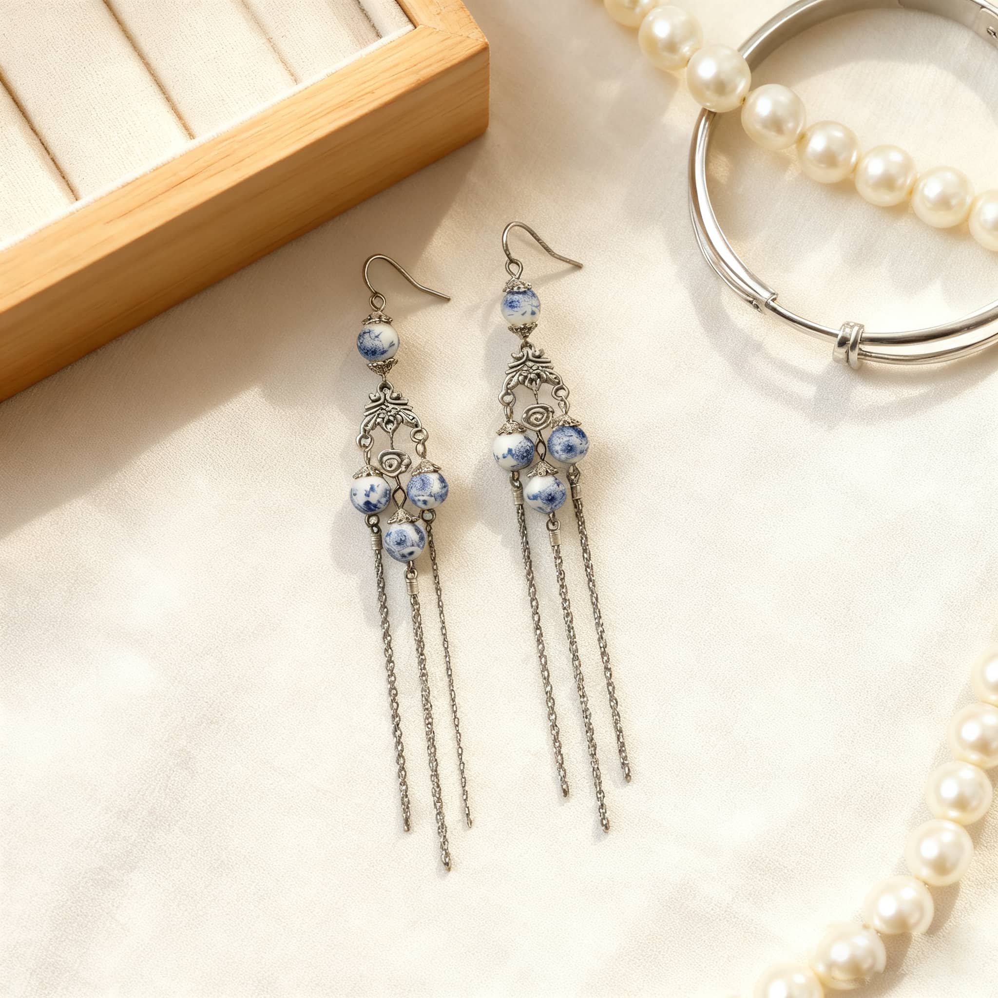 Elegant blue and white porcelain tassel earrings with dangling chains and intricate metal design
