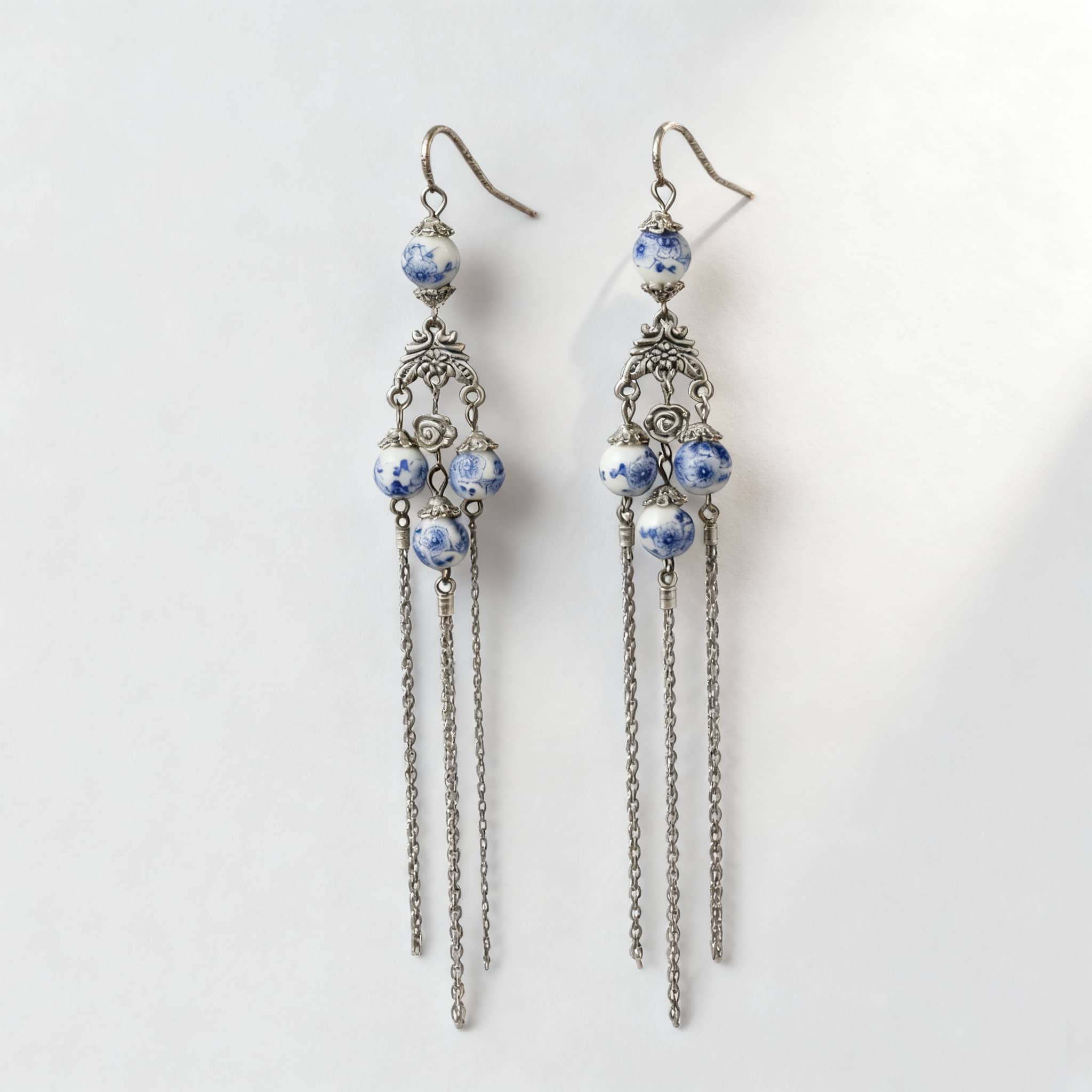 Elegant blue and white porcelain tassel earrings with silver accents and cascading chains