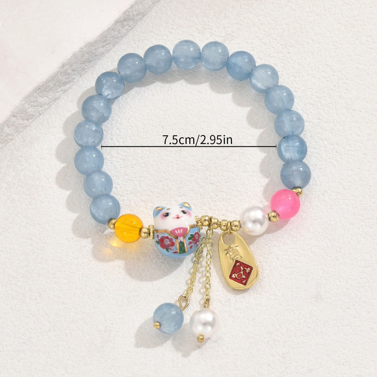 Blue crystal luck bracelet with cat charm, gold accents, colorful beads, and pearl details