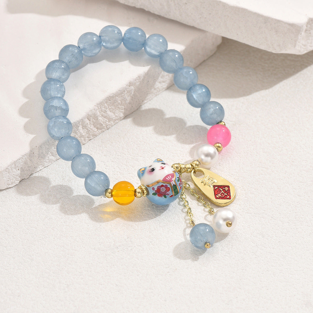 Blue crystal luck bracelet with beads, cat charm, and gold-tone accents for calm energy