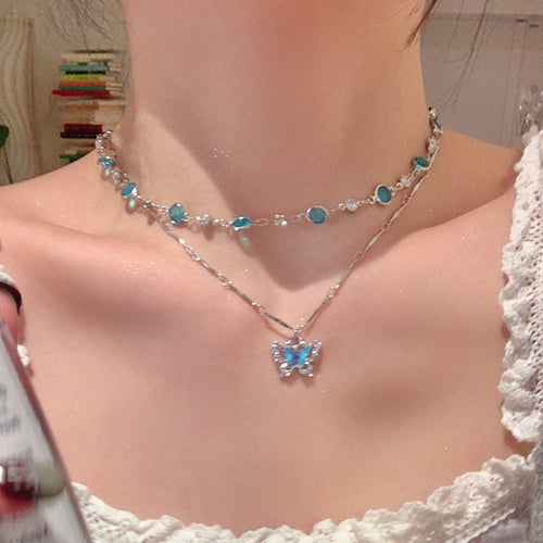 Blue gemstone butterfly necklace worn with matching blue and silver beaded choker on model