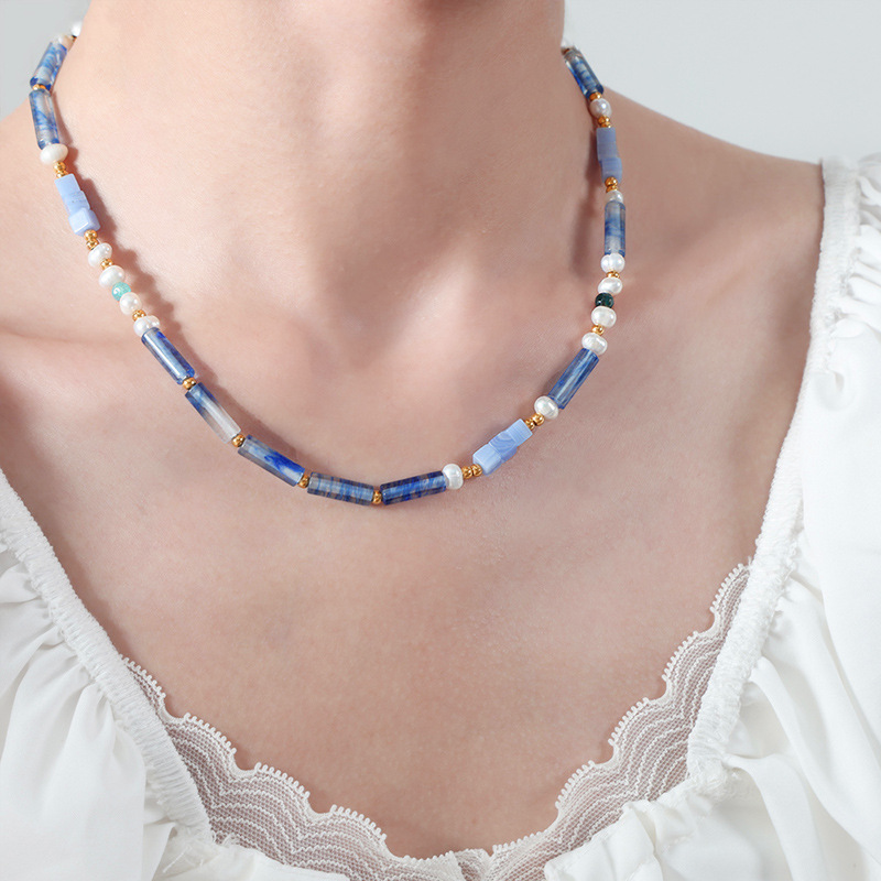 Blue and white beaded gemstone necklace worn with white lace neckline blouse
