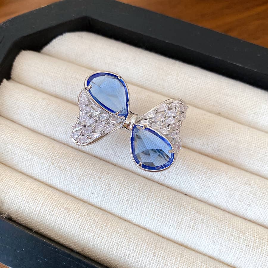 Elegant blue zircon bow ring designed by 5 Senses, featuring a unique sparkling bow shape.